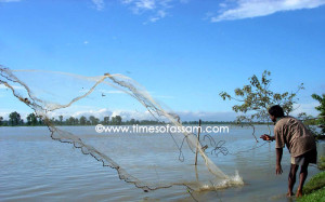 Man casts his fishing net at Disang river