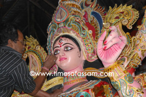 An idol maker applying finishing touches to a clay idol of Hindu goddess Durga An idol maker applying finishing touches to a clay idol of Hindu goddess Durga